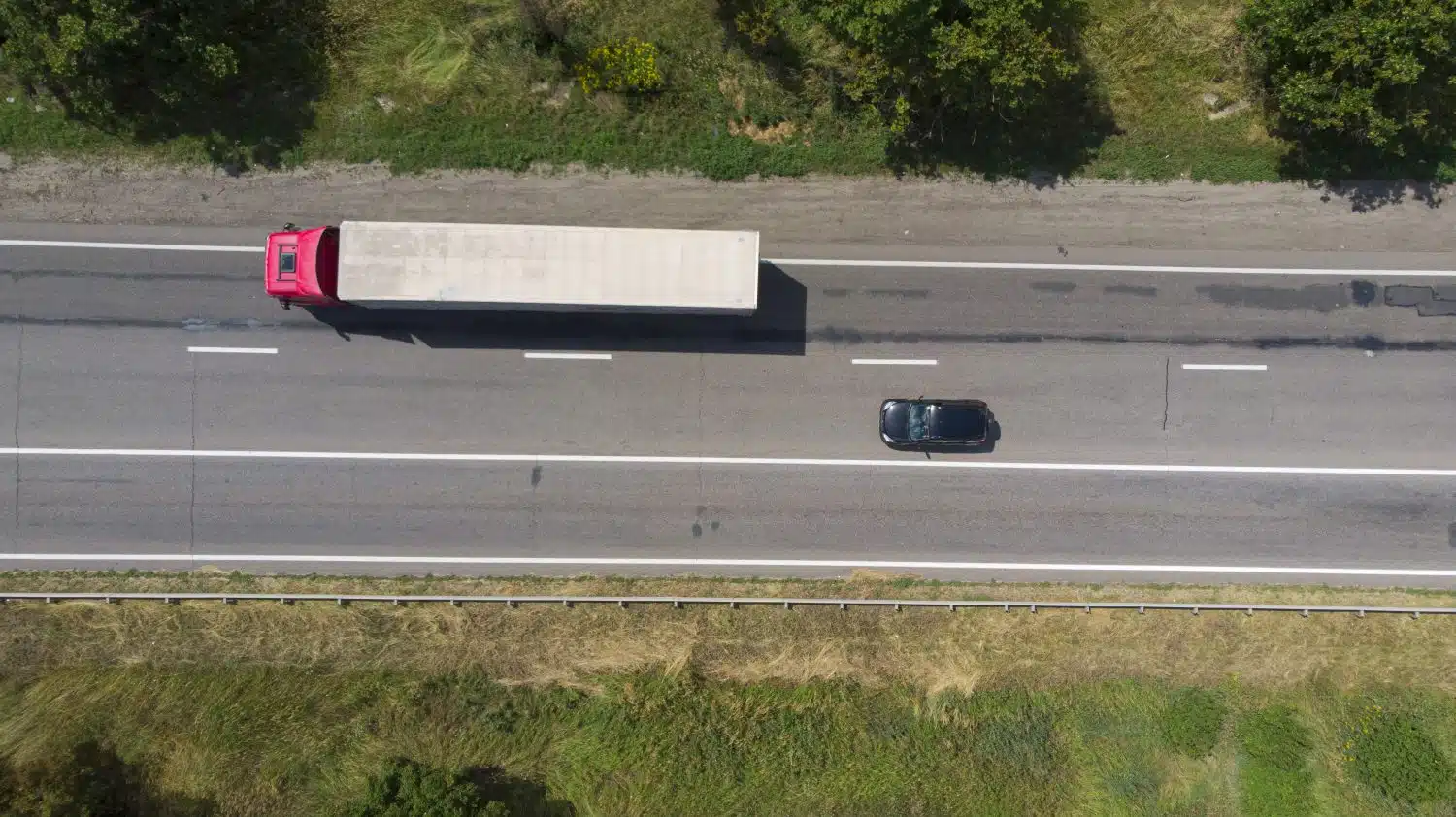 A car practices safe driving near an Arkansas tractor-trailer by keeping its distance.