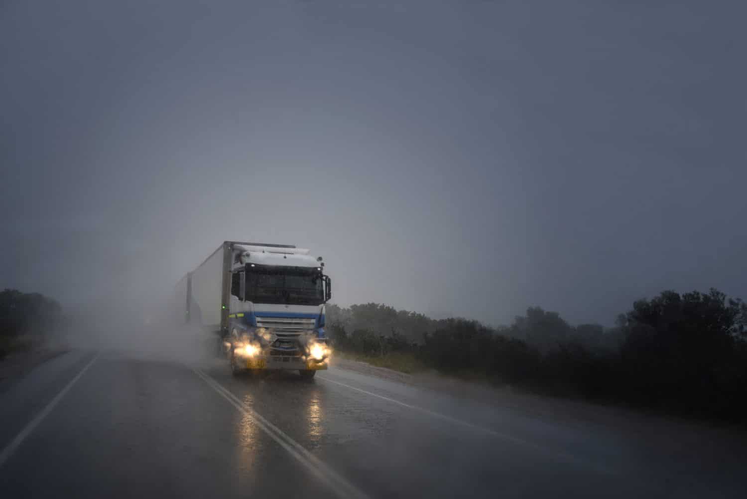 A commercial vehicle drives in the rain, increasing the risk of an Arkansas truck accident caused by bad weather.