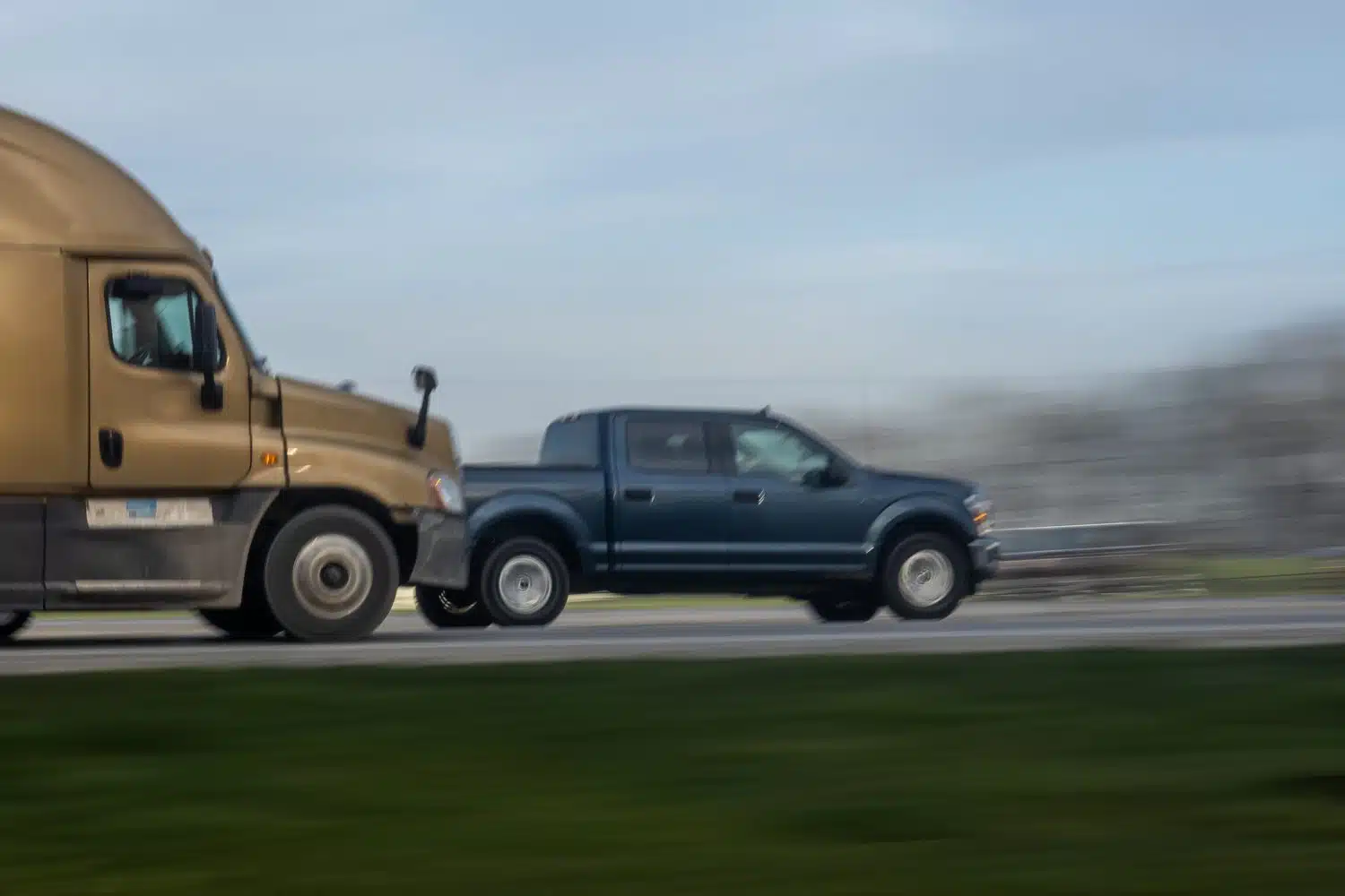 A tractor-trailer in Arkansas drives too closely to a blue pickup truck and almost causes a commercial truck accident.